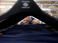John Orcutt, sorts out suit pants as they are manufactured and before they are matched to the corresponding jacket, at the Joseph Abboud manufacturing plant in New Bedford, MA.   [ PETER PEREIRA/THE STANDARD-TIMES/SCMG ]